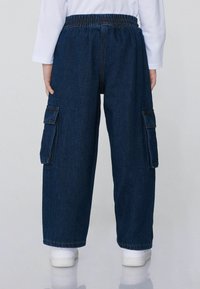 Džíny cargo kalhoty, tmavě modré, volného střihu, s elastickým pasem, obsahují boční kapsy a mají rovný střih, se zdobením jemnými švy.