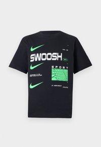 Črna bombažna majica s kratkimi rokavi, ki vključuje zeleno Nike blagovno znamko in grafično besedilo, z zelenim kvadratnim vzorcem kot dodatkom. Ovratnik je krogelne oblike.