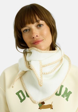 Bufanda de forro polar blanca con costuras beige, diseño triangular, envuelta alrededor del cuello, mostrando textura suave y apariencia estratificada.