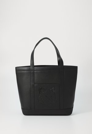 Bolso tote de cuero negro con forma alto y rectangular. Presenta un diseño de cabeza de animal en relieve en la parte frontal, dobles asas superiores y un acabado texturizado.