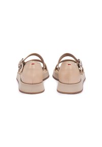 Sandali in pelle beige con una fibbia decorativa, cinturino posteriore e una suola imbottita beige. Finitura testurizzata con una leggera lucentezza.
