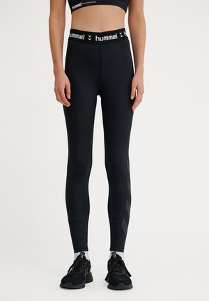 Sorte leggings lavet af strækstof med høj talje, der har et logo print og et chevron mønster langs den ydre side.