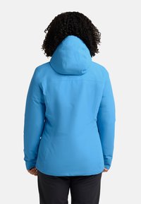 Veste imperméable bleue avec capuche, manches longues et design ajusté. Texture lisse sans quincaillerie ni motifs visibles.