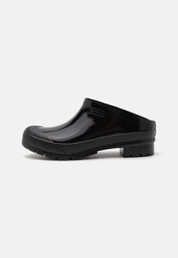 Black rubber clogs with a glossy finish, rounded toe, reinforced front, textured black outsole, and Barbour branding on the side.