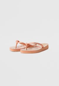 Pink flip-flops with textured straps and a floral-patterned footbed. Made from rubber with a flat sole. Features a slight heel for comfort.