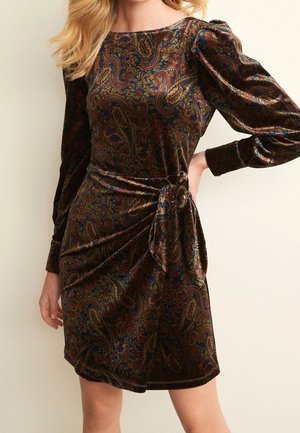 Robe en velours avec un motif cachemire en bleu foncé, rouge et or. Caractérisée par de longues manches bouffantes et un détail de taille nouée, coupe mi-genou.