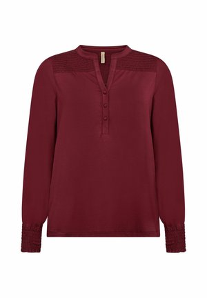 Burgundia pikkade varrukatega pluus ümmarguste kraede, kolme nupu lohku, smock-detailide õlgadel ja kokku surutud mansettidega. Pehme kude.