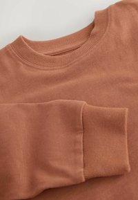 Lysbrun sweatshirt med ribbet rund hals og manchetter. Blød tekstur, minimalt design uden mønstre eller fremtrædende detaljer.