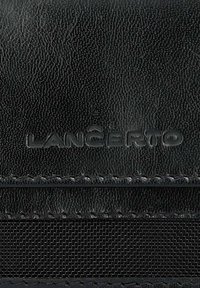 Czarny skórzany portfel z wytłoczonym logo "LANCERTO", fakturowaną powierzchnią i kontrastowymi przeszyciami. Kompaktowy i funkcjonalny design.