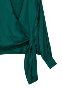 Grüne Satinbluse mit Wickeldesign, langen Ärmeln und gebundenem Akzent an der Taille. Glatte Textur und tiefer V-Ausschnitt.