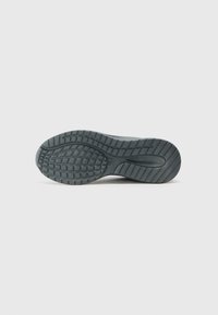 Black rubber shoe sole with a textured tread pattern. Features a rounded toe and contoured heel for enhanced grip and support.