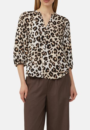 Tijgerprint blouse met een v-hals, 3/4 pofmouwen en een lichte, glanzende stof. Gecombineerd met losse, bruine broeken.