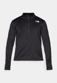 Pull à manches longues noir en tissu texturé, avec une fermeture éclair quart et un petit logo sur la poitrine. Manches ajustées avec des ouvertures pour les pouces.