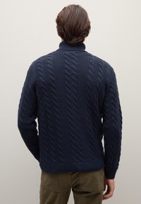 Marineblauer Strickpullover mit Zopfmuster, geripptem Kragen und Bündchen. Ansicht von hinten, zeigt das strukturierte Design.