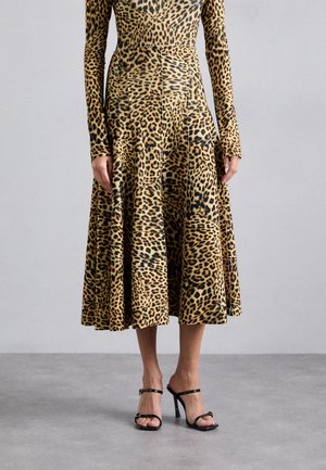 Vestido de estampado de leopardo con mangas largas y dobladillo acampanado, hecho de un textil suave. Cuenta con un corsé ajustado y se lleva con tacones negros con tiras.