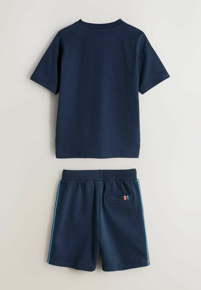 Camiseta de manga corta azul marino y pantalones cortos a juego con rayas multicolor en el bolsillo trasero y las costuras laterales de los pantalones cortos.