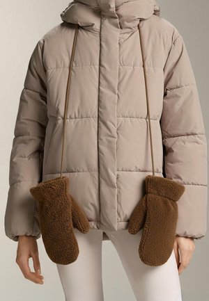 Kurtka typu puchówka w jasnobeżowym kolorze z kapturem, wyposażona w brązowe rękawiczki z polaru przymocowane sznurkami z przodu, zapewniające ciepło i wygodę.