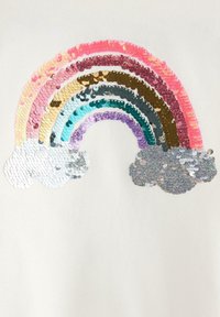 Vit tyg med en regnbåge av paljetter i rosa, guld, blått, grönt, lila och silver, med två silverfärgade molnaccent under.