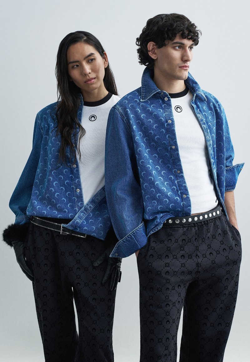 Denim-takit, joissa aaltoileva kuvio, valkoiset t-paidat, kuviolliset mustat housut ja hansikkaat. Asuissa on erottuvia tekstuureja ja malleja.