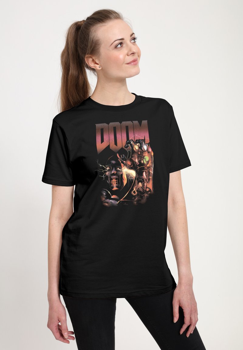 Czarna koszulka z kolorową grafiką z tekstem "DOOM", przedstawiająca potężną dłoń trzymającą kule na ciemnym tle.