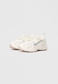 Tênis atléticos brancos com material de malha e sintético, apresentando um swoosh prateado, acentos texturizados e um design de sola grossa.
