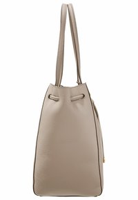 Beżowa skórzana torba tote o zarysowanej formie, z podwójnymi uchwytami i zapięciem na sznurki. Teksturowana powierzchnia z kontrastującym detalem przeszycia.