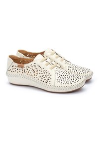 Zapatos de cuero blancos con patrones florales recortados, punta redondeada, acentos beiges y costuras en contraste. Suelas flexibles para mayor comodidad.