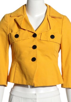 Veste courte jaune avec larges revers, trois grands boutons noirs sur le devant et deux poches poitrine boutonnées sur un mannequin blanc.