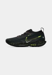 Black trail running shoe with Gore-Tex upper, reflective accents, green speckled midsole, and a prominent Nike logo. Robust design.