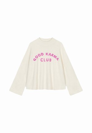Cream-colored, oversized sweater with wide sleeves. Features the text "GOOD KARMA CLUB" in bold, fuchsia lettering across the chest.