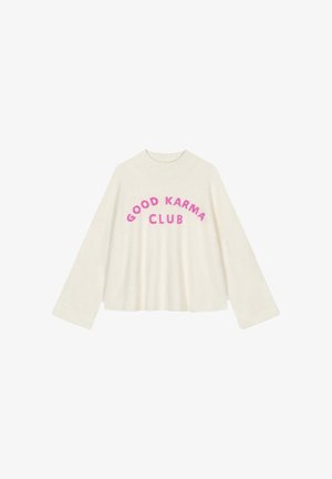 Cream-colored, oversized sweater with wide sleeves. Features the text "GOOD KARMA CLUB" in bold, fuchsia lettering across the chest.