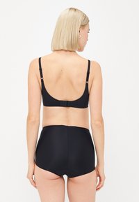 Svart bikini set med en enkel design; toppen har justerbara remmar och en traditionell hakstängning bak, i kombination med högmidjade bottnar.
