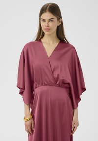 Satin-Wickelkleid in gedämpftem Rosaton, mit V-Ausschnitt, weiten Ärmeln und tailliertem Bund. Glatte Textur, fließendes Design, elegante Silhouette.