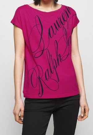 T-shirt fuchsia à manches courtes avec un grand texte en cursive noire. Tissu doux et lisse, coupe décontractée et design unique du col.