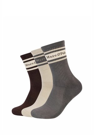 Trois paires de chaussettes côtelées montantes en marron foncé, beige et gris, chacune avec des rayures et le texte "Marc O'Polo" près du haut.
