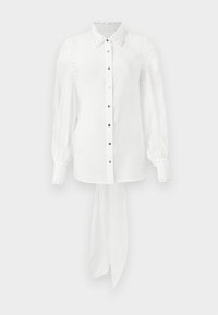 Balta ilgomis rankovėmis marškiniai su klasikiniu apykakle, blizgiais mygtukais, smeigimo detalėmis palei pečius ir raiščiu apatinėje dalyje. Lygus audinio tekstūra.