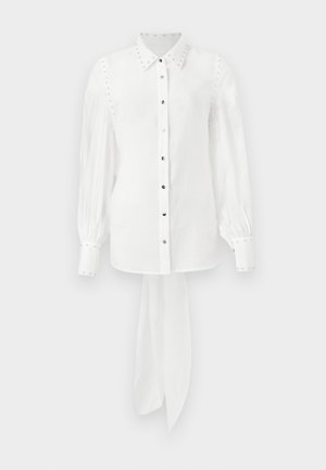 Valge pika varrukaga särk klassikalise kraega, läikivad nupud, nupudetailid õlgadel ja lips hemmi juures. Sile kangas.