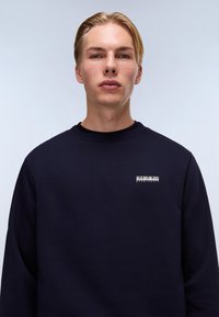 Felpa blu navy con scollatura rotonda e maniche lunghe. Presenta un piccolo logo bianco sul lato sinistro del petto. Realizzata in un morbido tessuto misto cotone.