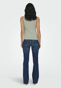 Grijze geribbelde tanktop gecombineerd met donkerblauwe flared jeans, voorzien van achterzakken en een gladde textuur. De top heeft een aansluitend ontwerp.