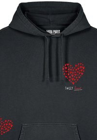 Fekete kapucnis pulóver piros szívmintával, apró szívek szórtan elhelyezve. A felirata "SWEET heart" fehér színben. Puha anyagból készült.