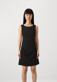 Vestido preto sem mangas com decote arredondado e um corte ligeiramente solto, apresentando detalhes drapeados de lado e uma textura suave.