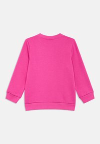 Rózsaszín pulóver hosszú ujjakkal, kerek nyakkal, bordázott mandzsettákkal és szegéllyel. Sima textúra, egyszínű, látható minták vagy grafikák nélkül.