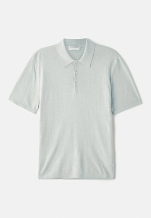 Polo bleu clair en tissu doux, avec un col classique, une patte de boutonnage à trois boutons et des manches courtes. Design minimaliste.