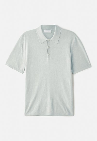 Lyseblå polo skjorte laget av mykt stoff, med krage i klassisk stil, tre-knappers stolpe og korte ermer. Minimalistisk design.