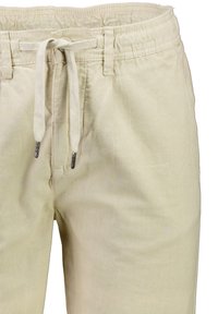 Beige linnen shorts met een elastische tailleband, trekkoord en een licht gestructureerde stof. Voorzien van metalen accenten op de uiteinden van het trekkoord.