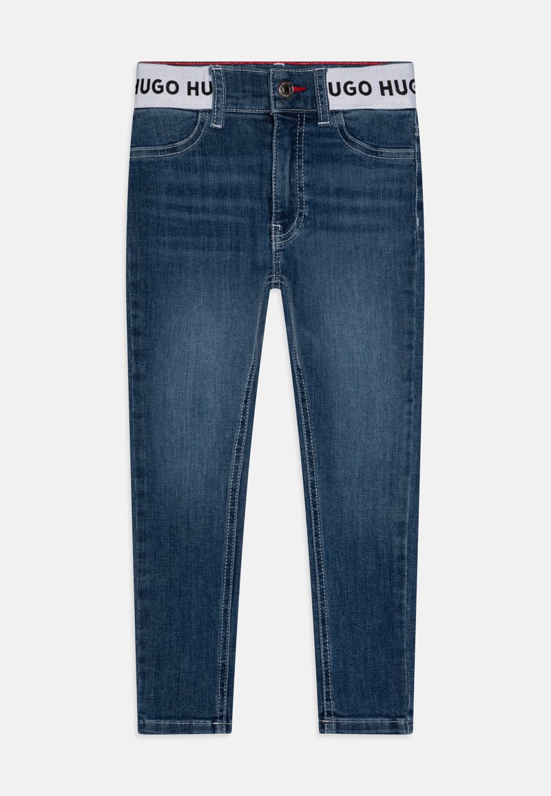 Tmavě modré džíny z denimu s přiléhavým střihem, s bílým páskem s potiskem "HUGO HUGO", designem s pěti kapsami a jemnými švy.