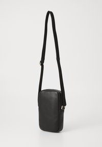 Schwarze Leder-Schultertasche mit rechteckiger Form, strukturiertem Oberflächen und verstellbarem Riemen. Verfügt über einen Reißverschluss und ein minimalistisches Design.