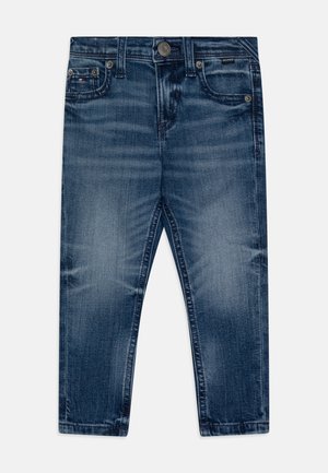 Jeans in denim blu scuro con un design classico a cinque tasche, chiusura a bottone e texture sbiadita per un aspetto vissuto.