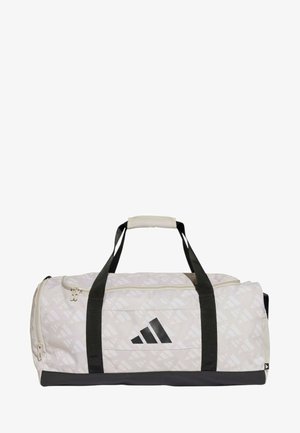 Il borsone presenta un tessuto beige chiaro con un motivo geometrico, accenti neri, manici robusti e un compartimento principale con zip.