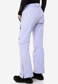 Pantaloni da sci viola chiaro con una vestibilità slim, dotati di tasche laterali con zip e un leggero svaso alla caviglia. Materiale testurizzato e resistente.